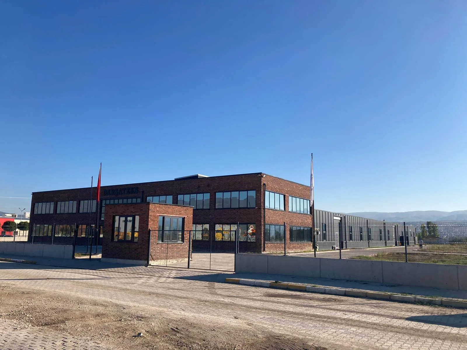 The new red-brick Darsateks factory and gatehouse in Erbaa under a deep blue sky in 2021