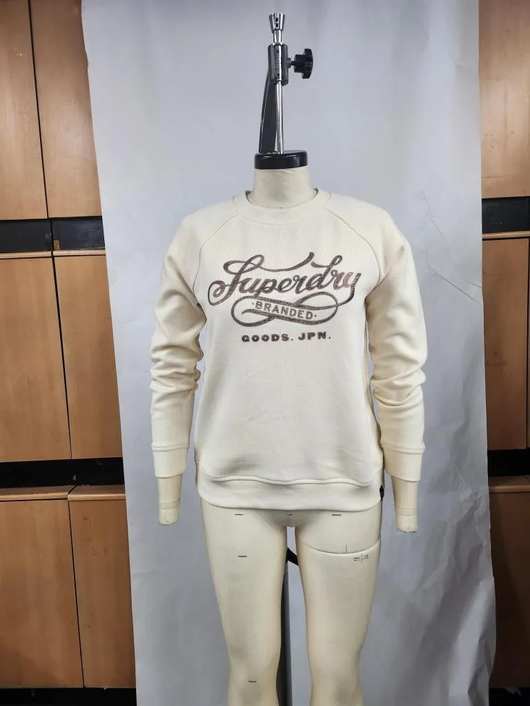 Sample of a cream sweatshirt with a Superdry script print on a fitting mannequin, made for Superdry